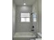 Bathroom featuring a shower-tub combo with marble-look tile and modern black fixtures at 3063 Sw 168Th Loop, Ocala, FL 34473