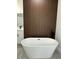 A soaking tub in a bathroom features a unique wooden wall design at 3063 Sw 168Th Loop, Ocala, FL 34473