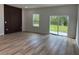 A bright living room with new floors, a unique wall design, and a sliding glass door at 3063 Sw 168Th Loop, Ocala, FL 34473