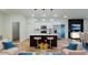Bright, open-concept living room featuring a modern kitchen with stainless steel appliances and pendant lighting at 3063 Sw 168Th Loop, Ocala, FL 34473
