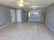 Open-concept living room flowing into the kitchen, featuring tile flooring and neutral paint at 3157 Britannia Blvd # B, Kissimmee, FL 34747