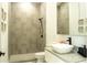 Modern bathroom features a stylish sink, dark hardware, and a walk-in shower with decorative neutral tiling at 346 Bowfin Ct, Kissimmee, FL 34759