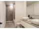 Modern bathroom featuring double vessel sinks, sleek vanity, and a tiled shower with glass door at 346 Bowfin Ct, Kissimmee, FL 34759