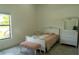 Bright bedroom with twin bed, dresser with mirror, and bench seat, lit by a sunlit window at 346 Bowfin Ct, Kissimmee, FL 34759