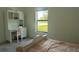 Bright bedroom featuring a twin bed, desk, and a sunlit window with a view of the green outdoors at 346 Bowfin Ct, Kissimmee, FL 34759