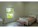 Bright bedroom featuring a twin bed, desk, and a sunlit window with a view of the green outdoors at 346 Bowfin Ct, Kissimmee, FL 34759