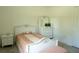 Bright bedroom with twin bed, dresser with mirror, and bench seat against a neutral toned wall at 346 Bowfin Ct, Kissimmee, FL 34759