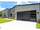 Modern home exterior features a sleek garage door, well-manicured lawn, and contemporary design at 346 Bowfin Ct, Kissimmee, FL 34759