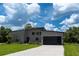 Modern home exterior with well-manicured lawn and sleek architectural lines featuring a long driveway at 346 Bowfin Ct, Kissimmee, FL 34759
