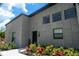 Modern home with well-manicured lawn and landscaping featuring a sleek front door and gray stone accents at 346 Bowfin Ct, Kissimmee, FL 34759