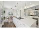 Open concept kitchen with stainless appliances, center island with cooktop, pendant lights, and views of the living and dining area at 356 N Spaulding Cv, Lake Mary, FL 32746
