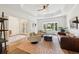 Bright living room featuring hardwood floors, tray ceilings, comfortable seating, and natural light at 356 N Spaulding Cv, Lake Mary, FL 32746