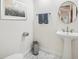 Neat powder room with pedestal sink, round mirror, stylish mosaic tile flooring, and a framed painting at 356 N Spaulding Cv, Lake Mary, FL 32746