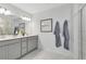 Clean and modern bathroom featuring dual sinks, a large mirror, and neutral color palette at 3610 Raindrop Way, Sanford, FL 32773