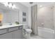 Neutral bathroom features a shower-tub combo, a modern vanity, and a framed mirror, offering a clean design at 3610 Raindrop Way, Sanford, FL 32773