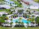 Aerial view of a community pool and clubhouse with palm trees and nearby homes with lake view at 3880 Sonoma Blvd, Kissimmee, FL 34741