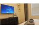 Comfortable bedroom featuring a mounted TV, dresser and modern décor, perfect for relaxing at 3880 Sonoma Blvd, Kissimmee, FL 34741