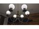 A stylish chandelier with round shades hangs in a room, offering a warm and inviting ambiance at 3880 Sonoma Blvd, Kissimmee, FL 34741
