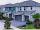 A row of modern homes are presented with manicured lawns, palm trees, and stylish teal and gray exterior paint at 3880 Sonoma Blvd, Kissimmee, FL 34741