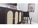 Stylish cabinet with cane door inserts, paired with a decorative chair and modern art at 3880 Sonoma Blvd, Kissimmee, FL 34741