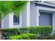 A well-maintained home features a gray garage door, neatly trimmed bushes, and a vibrant palm tree at 3880 Sonoma Blvd, Kissimmee, FL 34741
