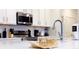 Modern kitchen featuring white cabinetry, quartz countertops, stainless steel appliances and chrome faucet at 3880 Sonoma Blvd, Kissimmee, FL 34741