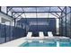 Covered pool and hot tub area featuring lounge chairs and privacy screens at 3880 Sonoma Blvd, Kissimmee, FL 34741