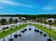 View of a tree-lined neighborhood with homes surrounding a pond under a clear sky at 3880 Sonoma Blvd, Kissimmee, FL 34741