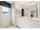 Bright bathroom featuring a double vanity, stylish mirrors, and a view of the exterior from the window at 405 Meadowland Pt, Oviedo, FL 32765