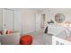 Bright Bedroom featuring a closet, round mirror, white dresser, crib, orange stool, and gray carpet at 405 Meadowland Pt, Oviedo, FL 32765
