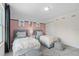 Stylish bedroom featuring two beds, striped ottomans, black out curtains, and pink and white walls at 405 Meadowland Pt, Oviedo, FL 32765