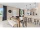 Dining area with a large table, chairs, and a bench next to a modern kitchen and bar seating at 405 Meadowland Pt, Oviedo, FL 32765