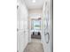 Hallway leading to a bedroom with a view of the outdoors, featuring a neutral color palette at 405 Meadowland Pt, Oviedo, FL 32765