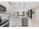 Open kitchen with stainless steel appliances and island overlooking a spacious, bright living area at 405 Meadowland Pt, Oviedo, FL 32765