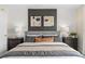 Cozy bedroom featuring nightstands, lamps, and a comfortable bed with an accent wall and artwork at 405 Meadowland Pt, Oviedo, FL 32765