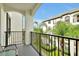Inviting balcony features seating with views of the palm trees, grass, and the adjacent buildings at 4114 Breakview Dr # 30702, Orlando, FL 32819