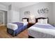 Comfortable bedroom featuring two twin beds, wooden floors, and decorative wall art at 4114 Breakview Dr # 30702, Orlando, FL 32819