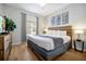 Bedroom with wood floors, queen bed, side tables, dresser and decorative art on the walls at 4114 Breakview Dr # 30702, Orlando, FL 32819