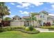 Elegant two-story home with manicured lawn, lush shrubbery and stately palm trees creating curb appeal at 4536 N Landmark Dr, Orlando, FL 32817