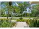 Charming front yard with lush tropical landscaping and a view of the tranquil lake across the street at 4536 N Landmark Dr, Orlando, FL 32817
