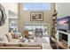 Bright living room featuring a fireplace, high ceilings, dark floors, and a view of the pool and lake at 4536 N Landmark Dr, Orlando, FL 32817