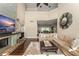 Open concept living room with fireplace, dark wood flooring, soaring ceilings, and an oversized ottoman at 4536 N Landmark Dr, Orlando, FL 32817