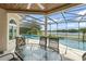Covered patio with dining table and lake view through the screened-in pool area at 4536 N Landmark Dr, Orlando, FL 32817