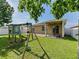 Backyard with green grass, playset, covered patio and white fence at 4553 Baler Trails Dr, St Cloud, FL 34772