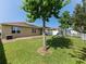 View of backyard with green grass, playset, covered patio and white fence at 4553 Baler Trails Dr, St Cloud, FL 34772