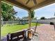 Backyard with covered brick patio, ceiling fan, and playset at 4553 Baler Trails Dr, St Cloud, FL 34772