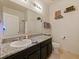 Well-lit bathroom featuring a granite countertop vanity, a toilet, and decorative potted plants at 4553 Baler Trails Dr, St Cloud, FL 34772