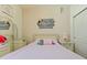 Cozy bedroom with neutral tones, wood decor, and a bed decorated with dolls and pillows at 4553 Baler Trails Dr, St Cloud, FL 34772