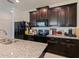Modern kitchen features dark cabinets, granite counters, and stainless steel appliances at 4553 Baler Trails Dr, St Cloud, FL 34772