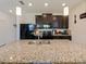 Modern kitchen features dark cabinets, granite counters, stainless steel sink, and pendant lighting at 4553 Baler Trails Dr, St Cloud, FL 34772